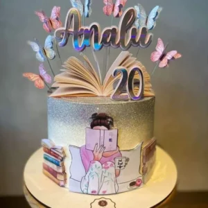Topper de bolo feminino com a silhueta de uma mulher sentada em uma poltrona aconchegante lendo um livro aberto, cercada por pequenas borboletas e xícaras de café flutuantes dispostas em camadas tridimensionais em arquivo digital de corte.