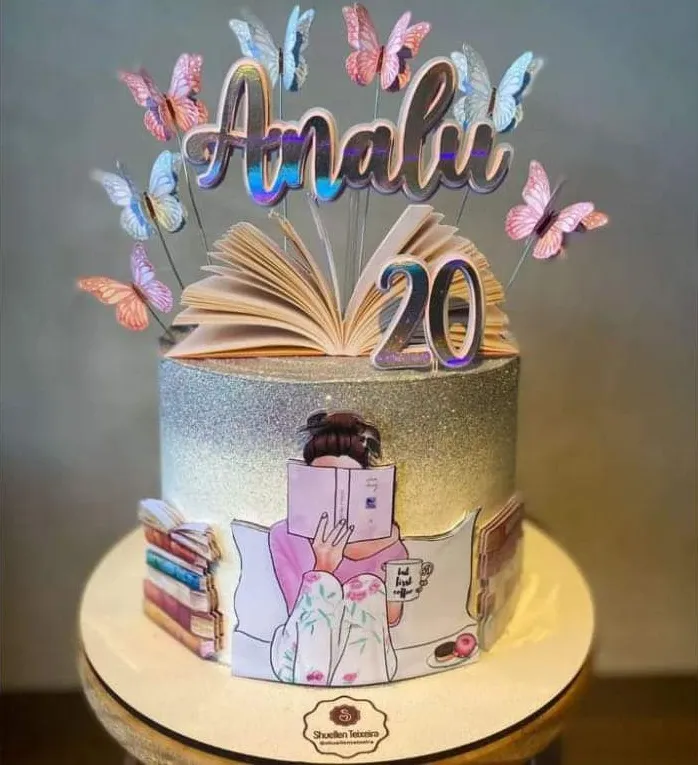 Topper de bolo feminino com a silhueta de uma mulher sentada em uma poltrona aconchegante lendo um livro aberto, cercada por pequenas borboletas e xícaras de café flutuantes dispostas em camadas tridimensionais em arquivo digital de corte.
