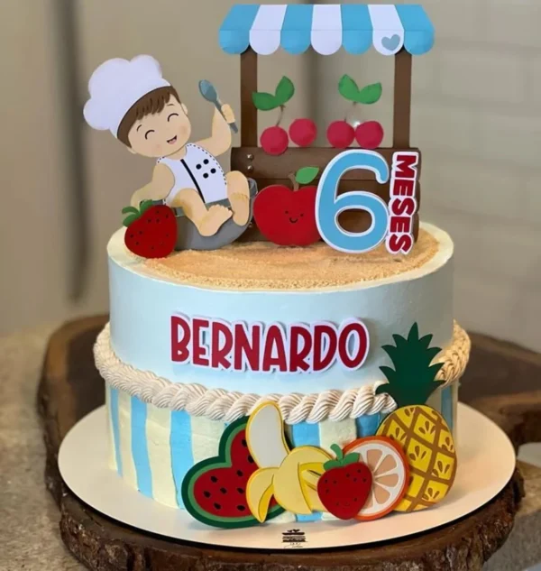 Topper de bolo de mesversário infantil exibindo fatias de melancia, bananas e morangos com rostinhos fofos e um grande número um centralizado, dispostos em camadas tridimensionais em arquivo digital de corte.