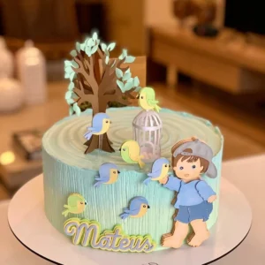 Gabarito digital de topo de bolo infantil com ilustração de um menino brincando no jardim rodeado por pequenos pássaros coloridos e árvores delicadas, exibindo as linhas estruturadas de contorno e camadas para recorte na Silhouette.