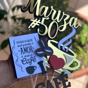 Topper de bolo com uma xícara de café fumegante marrom e branca sobre um pires, cercada por grãos de café torrados em tons de marrom e ramos com folhas e frutos vermelhos dispostos em camadas tridimensionais em arquivo digital de corte.