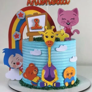 Topper de bolo com o palhacinho Plim Plim sorridente de braços abertos, usando sua roupa vermelha com uma grande estrela amarela no peito, cercado por um arco-íris colorido, nuvens brancas e notas musicais em camadas tridimensionais em arquivo digital de corte.