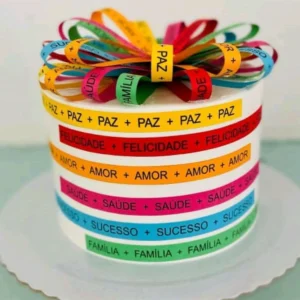 Topper de bolo com a fachada icônica da Igreja do Senhor do Bonfim em camadas brancas vazadas, decorado com uma profusão de fitinhas coloridas tradicionais baianas com mensagens de fé e proteção estendidas em relevo tridimensional em arquivo digital de corte.