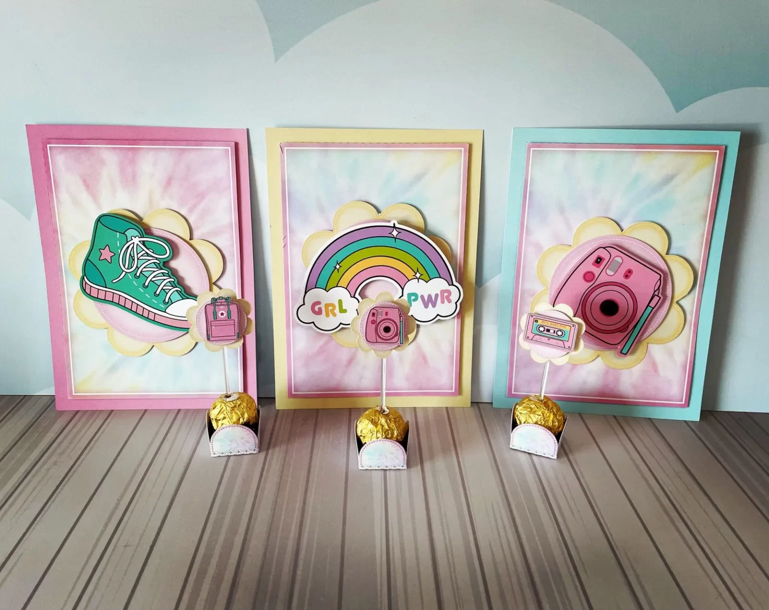 Arquivos digitais abertos em programa de recorte mostrando moldes de caixas sextavadas, tags com desenhos de girassóis e toppers de bolo do estilo Vsco Girl.