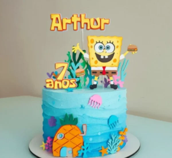 Arquivo de corte digital de topo de bolo no tema Bob Esponja em formato Studio para Silhouette, mostrando o personagem sorridente ao lado de sua casa de abacaxi, Patrick Estrela, águas-vivas e bolhas de ar dispostas em camadas prontas para recorte tridimensional.