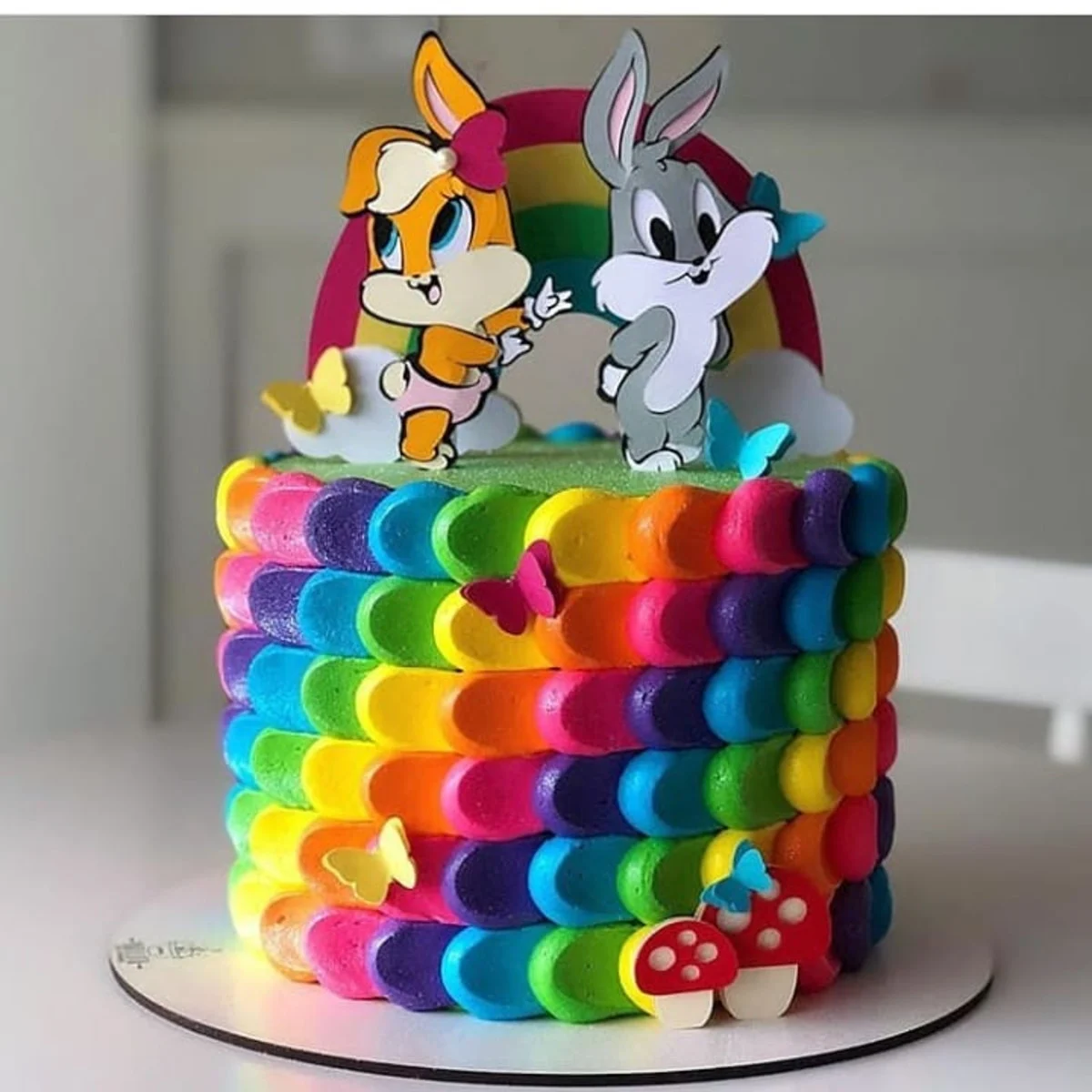 Arquivo de corte digital de topo de bolo do Pernalonga e Lola em suas versões Baby em formato Studio para Silhouette, exibindo os personagens com fraldas, mamadeira, cenouras e nuvens fofas dispostas em camadas para recorte tridimensional.