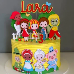 Arquivo de corte digital de topo de bolo do tema Sítio do Picapau Amarelo em formato Studio para Silhouette, mostrando a boneca Emília, o Visconde de Sabugosa, o Pedrinho e a Narizinho ao lado de árvores frutíferas e cercas rústicas em camadas para recorte tridimensional.
